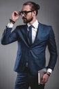 Handsome fashion businessman dressed in elegant blue suit on gray background Royalty Free Stock Photo