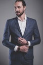 Handsome fashion businessman dressed in elegant blue suit on gray background Royalty Free Stock Photo