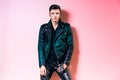 Handsome fashion man portrait, beautiful male model wear black leather jacket, pant and t-shirt posing near wall Royalty Free Stock Photo