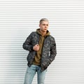 Handsome fashionable man in trendy military jacket with hoodie