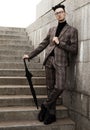 Fashionable young man in glasses with umbrella standing on the stairs Royalty Free Stock Photo