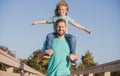 Handsome father piggybacking son playing on nature, daddy holding riding on back adorable cheerful kid boy enjoy active