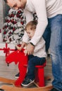 Handsome father playing with his small cute son near decorated New year tree Royalty Free Stock Photo