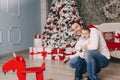 Handsome father playing with his small cute son near decorated New year tree Royalty Free Stock Photo