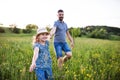 Father with a small daughter running in spring nature.