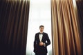 Handsome fiance stands between the beig curtains Royalty Free Stock Photo