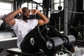 Handsome fit african man in sportwear doing crunches using a bench at gym.