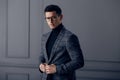 Handsome,fit man in gray suit with black turtleneck,black stylish eyeglasses looks confident at the camera. Royalty Free Stock Photo