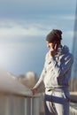 Handsome fit man taking a break after intensive training outdoors, talking on his smart phone wearing headphones Royalty Free Stock Photo