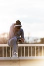 Handsome fit man taking a break after intensive training outdoors, texting on his smart phone wearing headphones Royalty Free Stock Photo