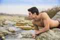 Handsome fit shirtless young man laying on rock