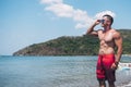 A handsome, fit, tanned, and attractive Filipino man wearing shades and board shorts at the beach. Summertime concept Royalty Free Stock Photo