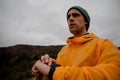 Handsome fit young male hiker checking heart rate on smartwatch while hiking on mountain path in cloudy weather Royalty Free Stock Photo