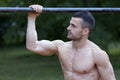 Handsome fit young man doing exercises on the horizontal bar and Royalty Free Stock Photo