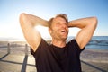 Handsome fitness man laughing with hands behind head