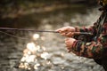 Handsome fly fisherman fly fishing on a splendid mountain river for rainbow trout