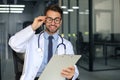 Handsome friendly young doctor on hospital corridor looking at camera, smiling Royalty Free Stock Photo