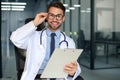 Handsome friendly young doctor on hospital corridor looking at camera, smiling Royalty Free Stock Photo