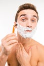 Handsome funny man with shaving foam on his face and razor Royalty Free Stock Photo