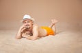 Handsome funny man wearing hat lying down on the sand