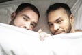 A Handsome gay men couple on bed together under the cover Royalty Free Stock Photo