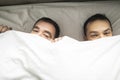 A Handsome gay men couple on bed together under the cover Royalty Free Stock Photo