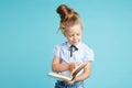 Handsome girl holding white book in hands in the blue room.