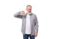 handsome gray-haired elderly man in a shirt doubts on a white background with copy space