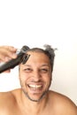 Handsome gray-haired man is cutting hair himself