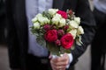 Handsome groom in black suit holding wedding bouquet Royalty Free Stock Photo