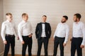 Handsome groom with his groomsman at home. Five man. Groom dressed in suit, gromsmen in white shirt. Funny guys on the