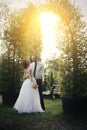 Handsome groom holds the bride`s hand near green flower archway Royalty Free Stock Photo