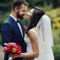 Handsome groom hugging beautiful bride with bouquet in romantic Royalty Free Stock Photo