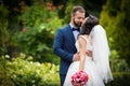 Handsome groom kissing beautiful bride with bouquet in romantic Royalty Free Stock Photo