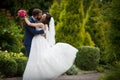 Handsome groom kissing beautiful bride with bouquet in romantic Royalty Free Stock Photo