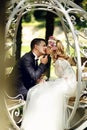 Handsome groom kissing blonde beautiful bride in magical fairy t