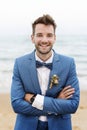 Handsome groom smiling at the beach