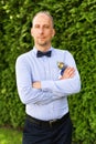 Handsome groom in a wedding tuxedo smiling and waiting for the bride. Outdoor wedding ceremony. Royalty Free Stock Photo