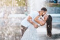 Handsome guy and beautiful girls kissing on the background of a fountain Royalty Free Stock Photo