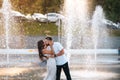 Handsome guy and beautiful girls kissing on the background of a fountain Royalty Free Stock Photo