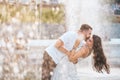 Handsome guy and beautiful girls kissing on the background of a fountain Royalty Free Stock Photo