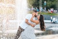 Handsome guy and beautiful girls kissing on the background of a fountain Royalty Free Stock Photo