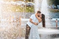 Handsome guy and beautiful girls kissing on the background of a fountain Royalty Free Stock Photo