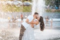 Handsome guy and beautiful girls kissing on the background of a fountain Royalty Free Stock Photo