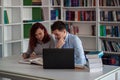 Handsome guy and beautiful redhead girl studying in the library Royalty Free Stock Photo