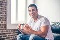 Handsome guy in a chair with a cup in his hands. Royalty Free Stock Photo