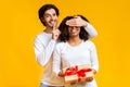 Handsome guy covering his girlfriend`s eyes, giving her present Royalty Free Stock Photo