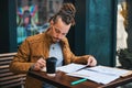 Creative young man studying in street cafe Royalty Free Stock Photo