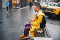 Young man with gadgets waiting for friend on bench Royalty Free Stock Photo