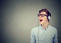 Handsome guy with headphones in blue shirt listening to music and singing Royalty Free Stock Photo